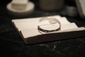 Silver Bracelet on a Piece of Stone on a Table